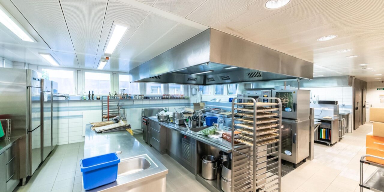 Die Produktionsküche im RegioFood Hub: Edelstahlflächen, Kombisteamer, Backblechwagen und viel Platz zum Arbeiten.